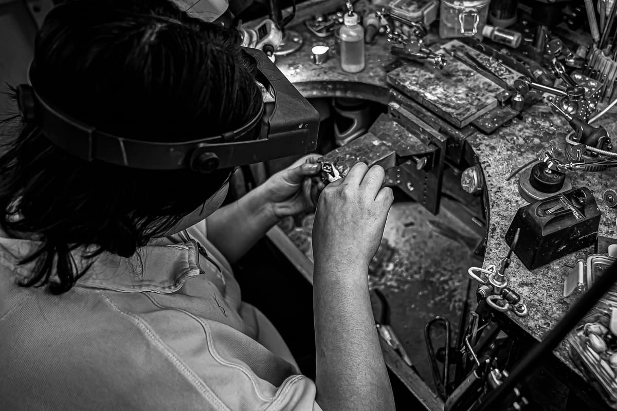 Master jeweler repairing a ring on her ring bench
