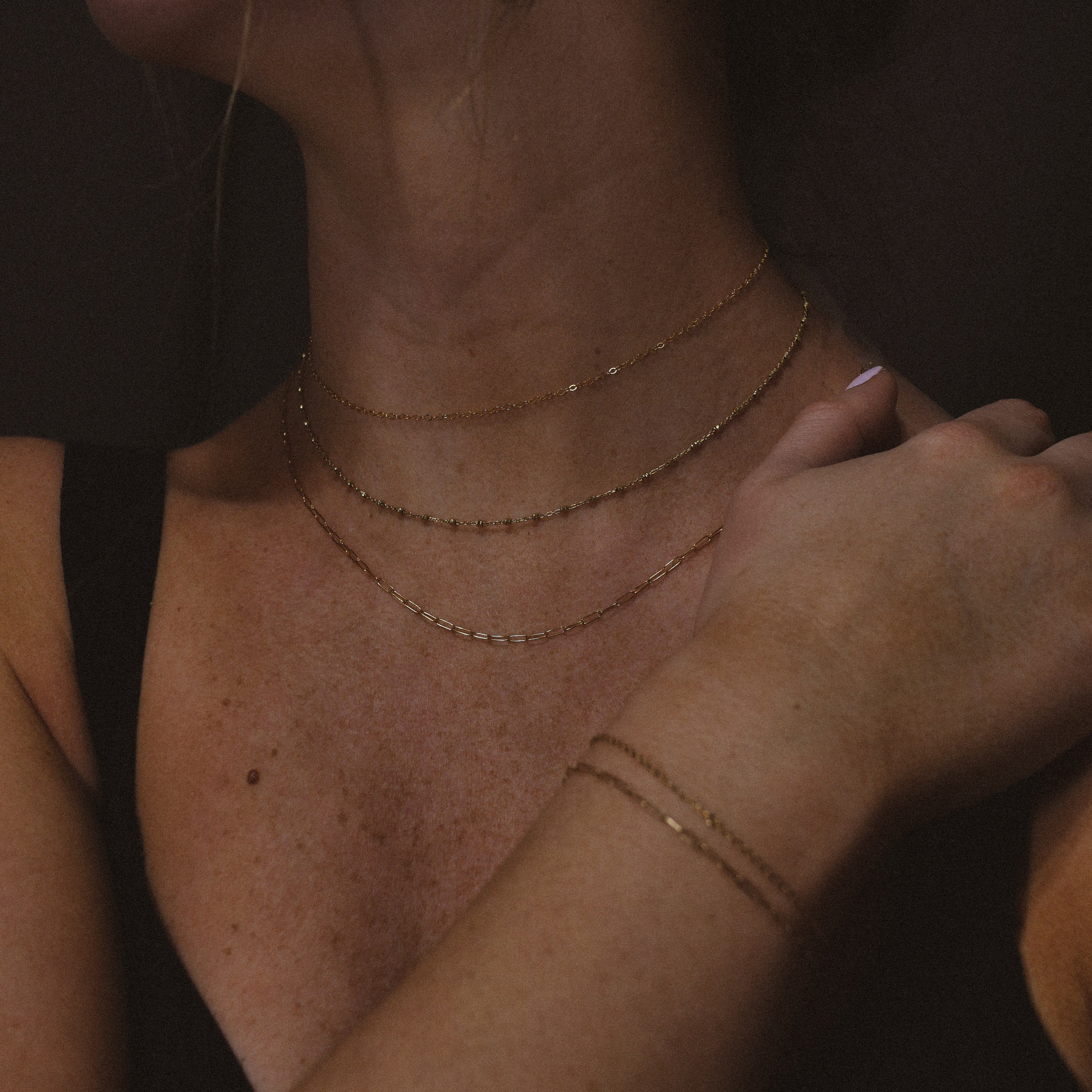 A Woman wearing permanent gold jewelry necklaces and bracelets