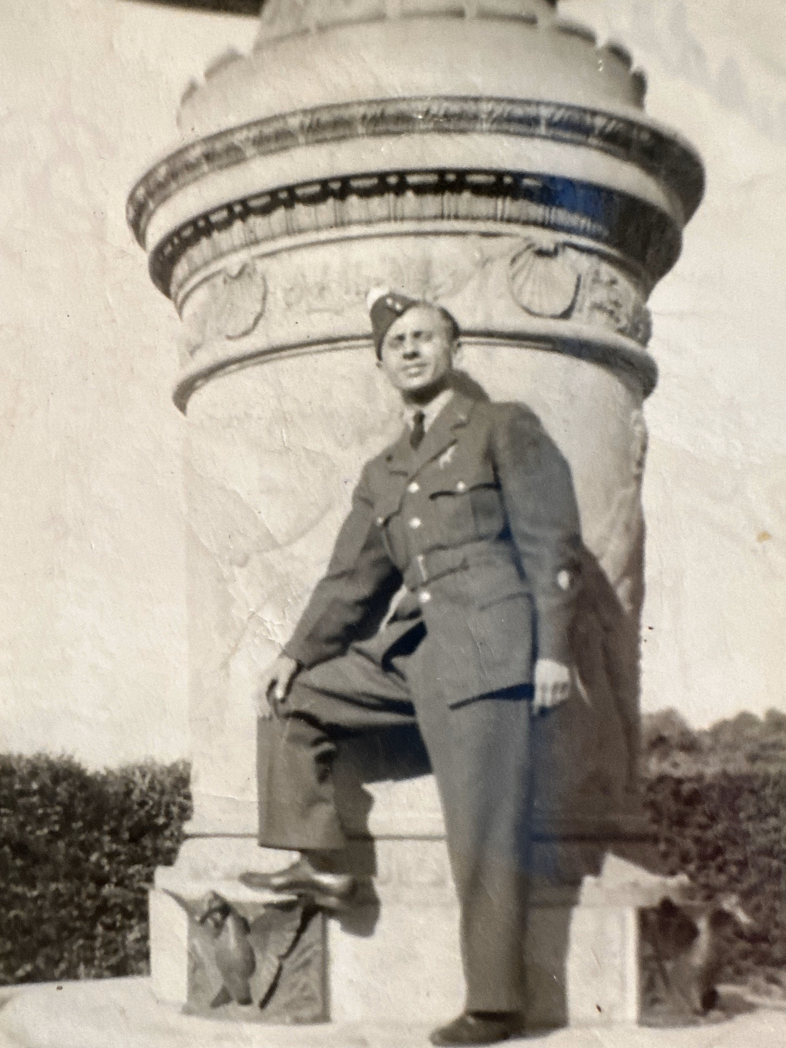 Papa in military uniform next to a statue 